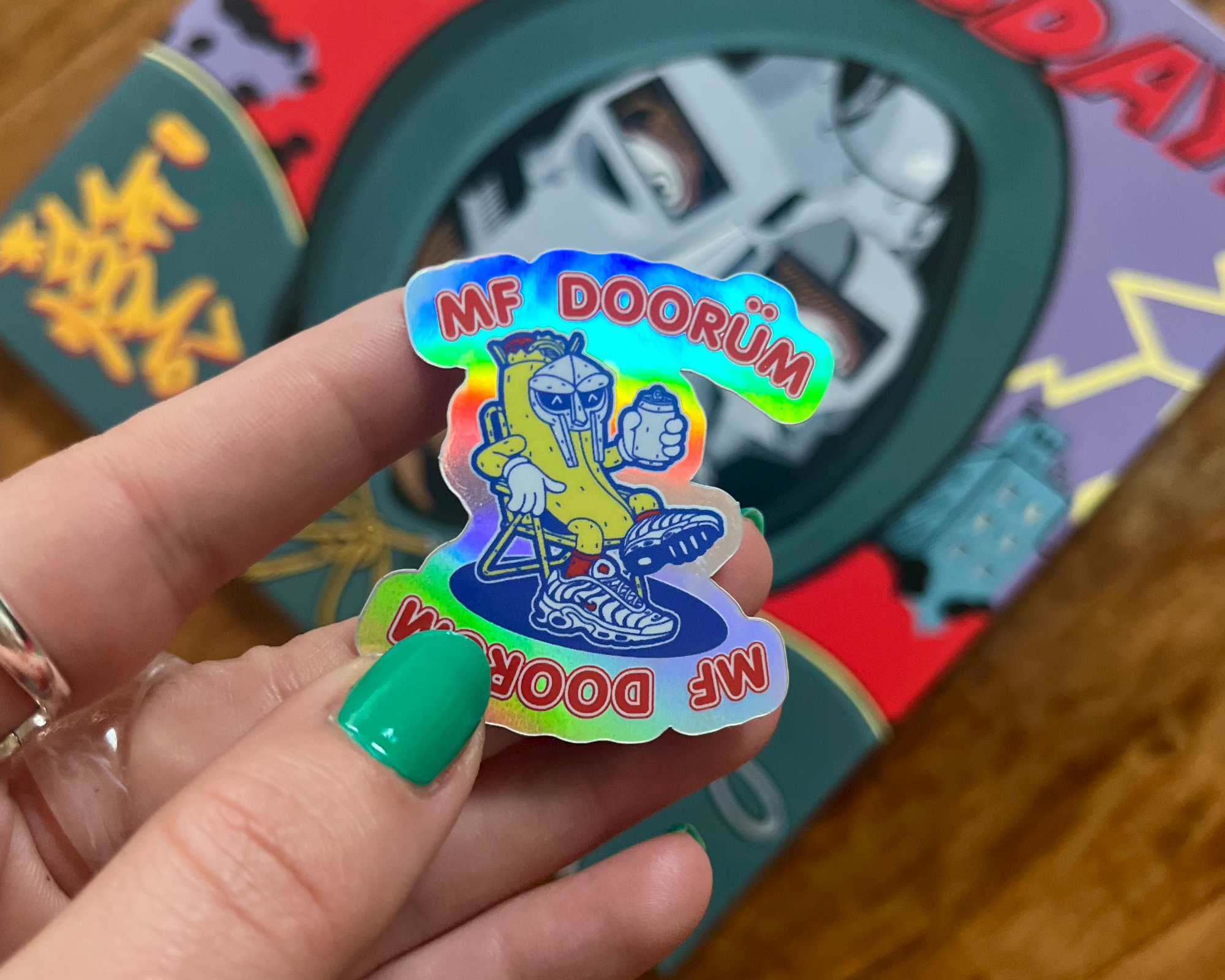 A person holding aMF DOORUM holographic sticker