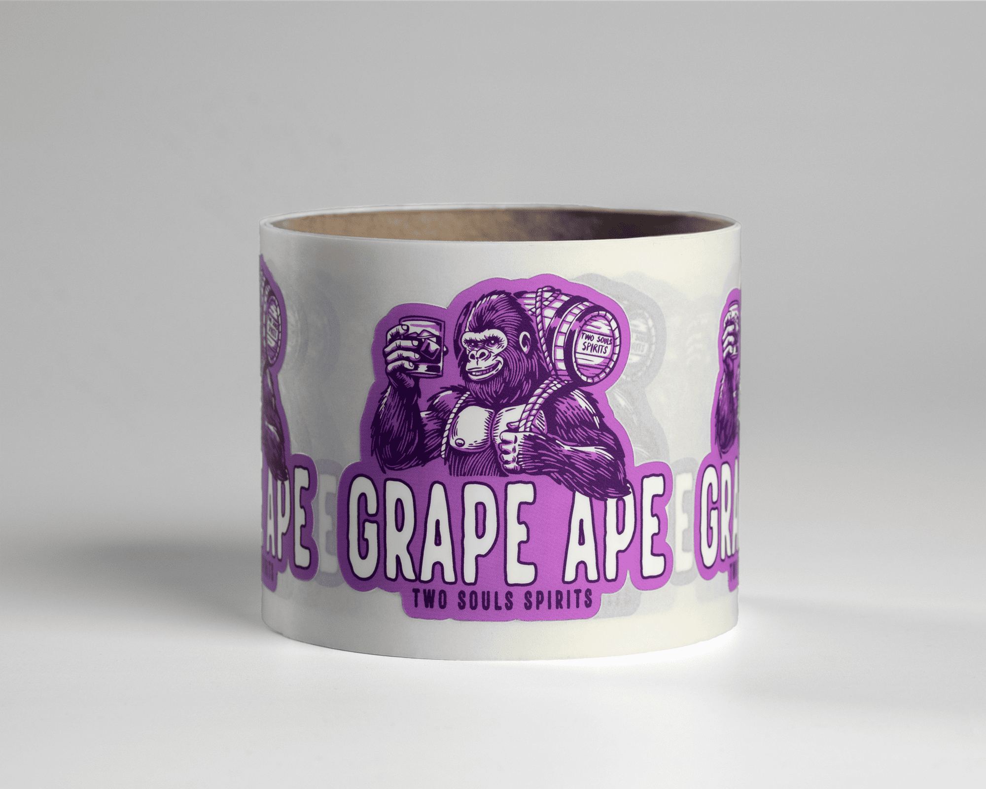 Roll of labels featuring a purple gorilla holding a barrel and glass, labeled "Grape Ape" and "Two Souls Spirits" on a white background.