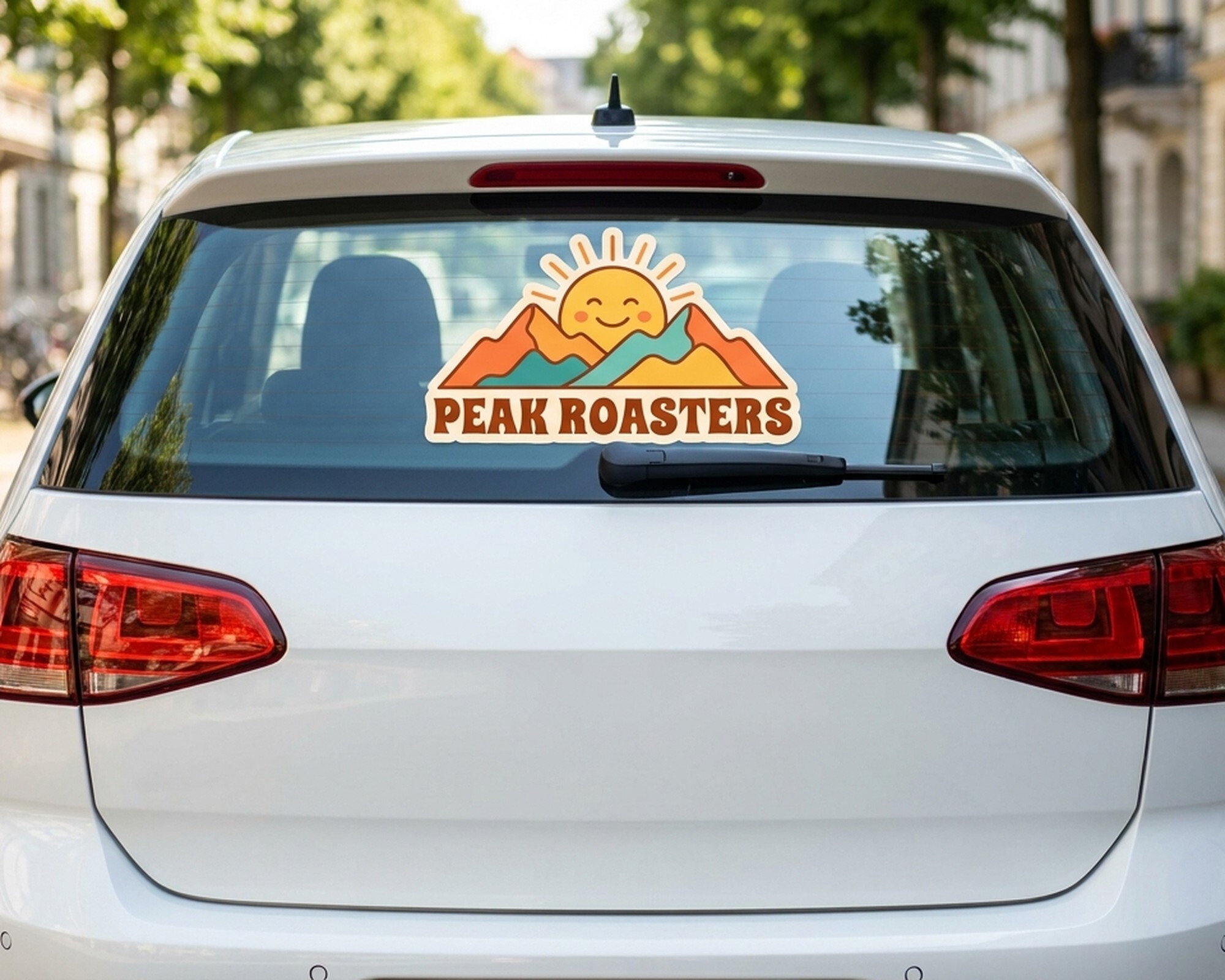 Konturskåret decal med et logo med sol og bjerge og teksten "Peak Roasters" på en bils bagrude